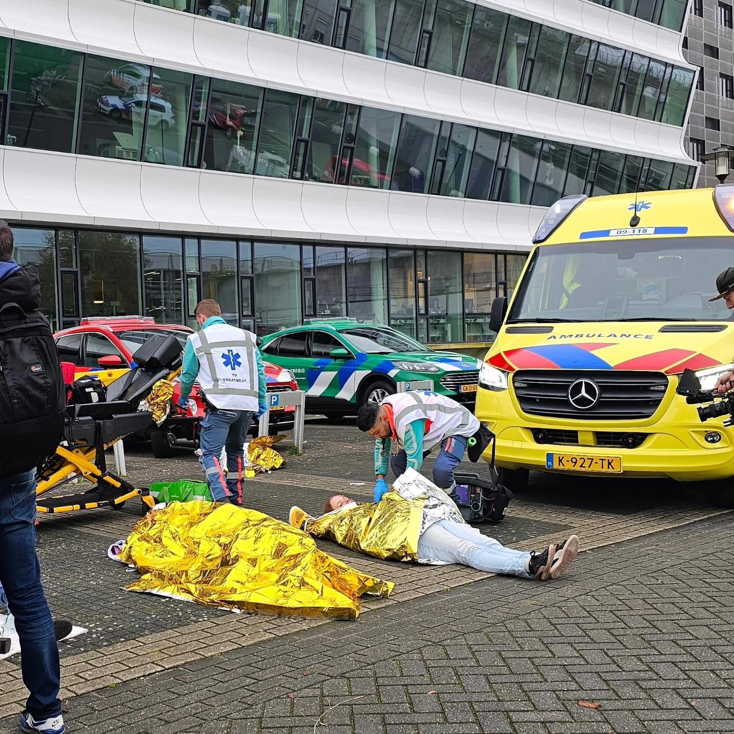 Ambulancepersoneel helpt slachtoffers met een warmtedeken