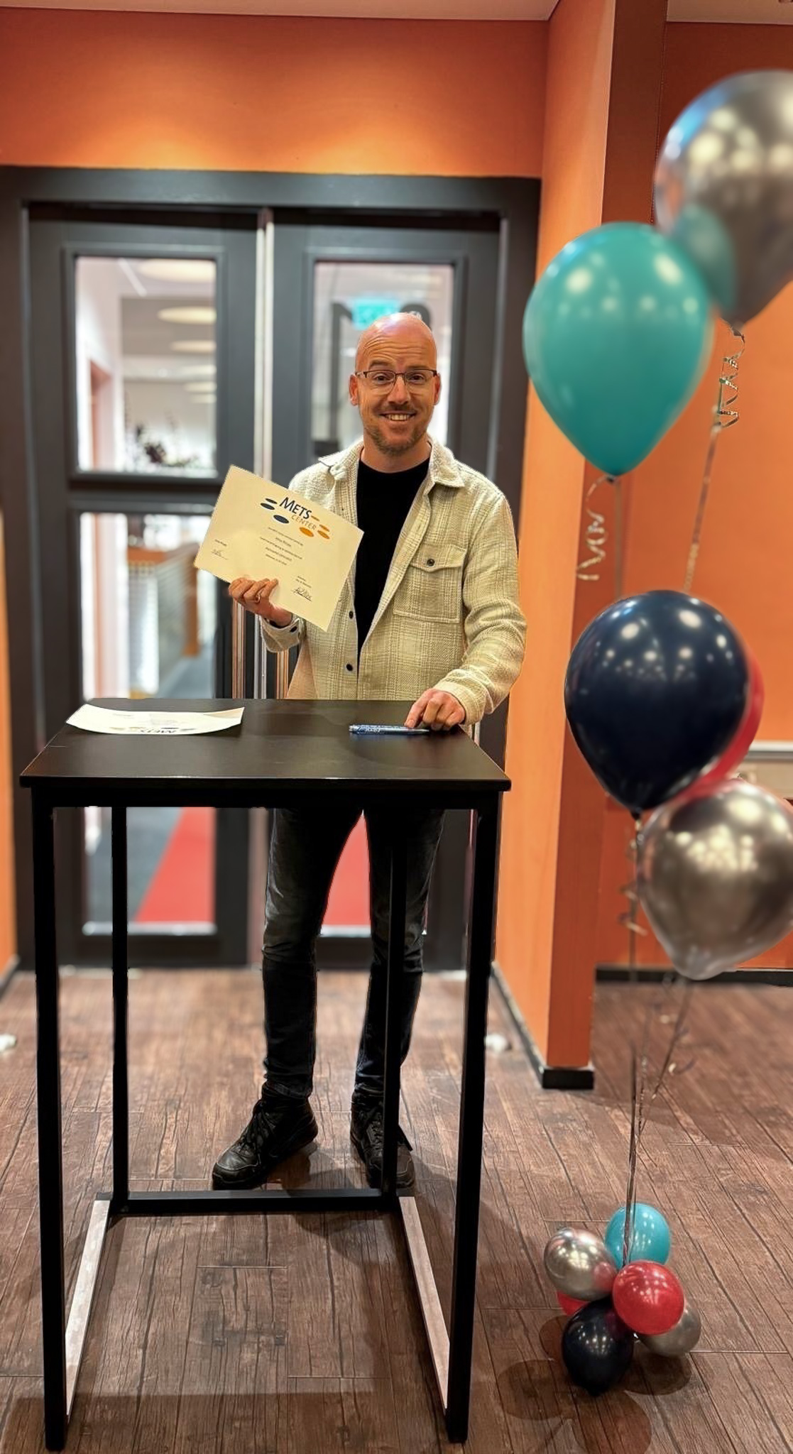 Meldkamercentralist Mike ondertekent zijn diploma in het METS-centrum in Bilthoven
