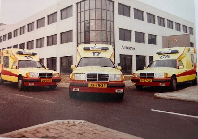 Oude ambulances staan geparkeerd voor een gebouw
